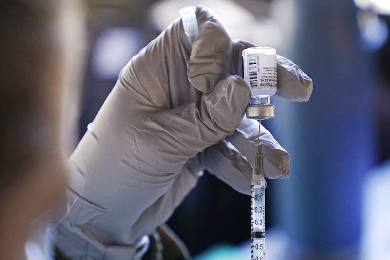 Megan Turgeon, of the New Hampshire National Guard, fills a syringe with the Pfizer COVID-19 vaccine at a clinic. Two new studies have shown promise when a single dose of the vaccine is given to health care workers who have already had the coronavirus.